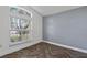 Bright bedroom featuring a large window, gray accent wall and wood-look herringbone flooring at 655 Eagle Pointe South, Kissimmee, FL 34746
