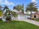 Beautiful home featuring a well-manicured lawn, a grey garage, and palm trees at 655 Eagle Pointe South, Kissimmee, FL 34746