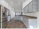 Spacious kitchen featuring sleek gray cabinets, stainless steel appliances, and modern herringbone floors at 655 Eagle Pointe South, Kissimmee, FL 34746