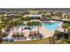 Aerial view of the community pool, clubhouse, and surrounding homes in the neighborhood at 6935 Dilly Lake Ave, Groveland, FL 34736
