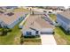Aerial view of the home with a well-kept lawn, solar panels and two car garage at 6935 Dilly Lake Ave, Groveland, FL 34736