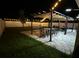Relaxing backyard offers patio, pergola, seating, and hammock under festive cafe lights at 6935 Dilly Lake Ave, Groveland, FL 34736