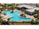 Aerial of sparkling community pool, clubhouse and splashpad, complete with lounging and palm trees at 6935 Dilly Lake Ave, Groveland, FL 34736