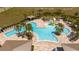 Aerial shot showcasing the zero entry community pool with splashpad, lounge chairs, and umbrellas at 6935 Dilly Lake Ave, Groveland, FL 34736