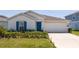 Charming single-story home with a well-manicured lawn and a bright blue front door at 6935 Dilly Lake Ave, Groveland, FL 34736