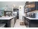 Open kitchen with stainless steel appliances, dark cabinetry, and tile flooring at 6935 Dilly Lake Ave, Groveland, FL 34736