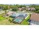 Aerial view of a home with a screened pool, lush landscaping, and a well-maintained lawn at 71 Lazy Eight Dr, Port Orange, FL 32128