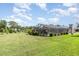 Expansive backyard view featuring a screened-in pool, lush lawn, and mature landscaping at 71 Lazy Eight Dr, Port Orange, FL 32128