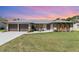 Charming single-story home featuring a brick facade, well-manicured lawn, and a cozy front patio at 71 Lazy Eight Dr, Port Orange, FL 32128