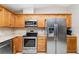 Bright kitchen with wood cabinets, stainless steel appliances, and modern tile flooring at 71 Lazy Eight Dr, Port Orange, FL 32128