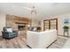 Cozy living room featuring a brick fireplace, wood floors, comfortable seating, and abundant natural light at 71 Lazy Eight Dr, Port Orange, FL 32128