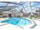 Screened in pool area featuring a sparkling blue pool, patio seating, and a lush backyard view at 71 Lazy Eight Dr, Port Orange, FL 32128