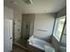 Modern bathroom featuring a glass-enclosed shower and separate soaking tub with window at 738 Pointe Emerson Blvd, Apopka, FL 32703