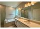 Elegant bathroom featuring double sinks, a soaking tub, and modern fixtures at 738 Pointe Emerson Blvd, Apopka, FL 32703