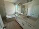Modern bathroom with double vanity, soaking tub, glass-enclosed shower, and bright natural light at 738 Pointe Emerson Blvd, Apopka, FL 32703