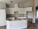 Bright kitchen featuring white cabinetry, an island, and modern design elements at 738 Pointe Emerson Blvd, Apopka, FL 32703