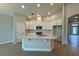 Bright kitchen featuring white cabinets, an island with seating, and stainless steel appliances at 738 Pointe Emerson Blvd, Apopka, FL 32703