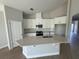 Bright kitchen with white cabinets, stainless steel appliances, large island, and modern backsplash at 738 Pointe Emerson Blvd, Apopka, FL 32703