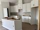 Bright kitchen featuring white cabinetry, an island, and modern design elements at 738 Pointe Emerson Blvd, Apopka, FL 32703