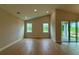 Spacious living room featuring vaulted ceilings, wood floors, and large windows showcasing the outdoor view at 738 Pointe Emerson Blvd, Apopka, FL 32703
