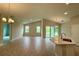 Open-concept living space featuring wood-look tile floors, ample lighting, and a modern kitchen island at 738 Pointe Emerson Blvd, Apopka, FL 32703