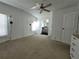 Bright bedroom featuring wood paneling, a ceiling fan, and an attached bathroom at 741 Truman Ave, Lady Lake, FL 32159