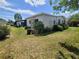 Exterior home view with lush landscaping, a screened patio, and ample yard space at 741 Truman Ave, Lady Lake, FL 32159