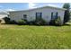 Home exterior enhanced by green lawn, garden trellises, and neat shrubbery at 741 Truman Ave, Lady Lake, FL 32159