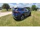 A blue SUV sits on a grass lawn next to the house at 741 Truman Ave, Lady Lake, FL 32159