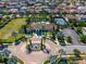 Aerial view of a community center with a pool, tennis courts, parking, and surrounding houses at 8625 Brixford St, Orlando, FL 32836