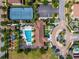 Aerial view of the community clubhouse, pool, tennis courts, parking, playground, and roundabout entrance at 8625 Brixford St, Orlando, FL 32836