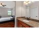 Ensuite bathroom with granite countertops, wooden cabinets, and a view into the bedroom at 8625 Brixford St, Orlando, FL 32836