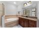 Bathroom with a granite countertop vanity, soaking tub, and glass shower enclosure at 8625 Brixford St, Orlando, FL 32836