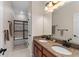 Bathroom featuring dual sinks with granite countertops, wooden cabinets, and modern fixtures at 8625 Brixford St, Orlando, FL 32836