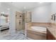 Bathroom showcasing glass shower, soaking tub, granite vanity, and marble floors at 8625 Brixford St, Orlando, FL 32836