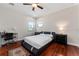Bright bedroom featuring a ceiling fan, windows, hardwood floors, and a modern black platform bed frame at 8625 Brixford St, Orlando, FL 32836