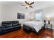 Comfortable bedroom with hardwood floors, a ceiling fan, and a relaxing seating area at 8625 Brixford St, Orlando, FL 32836