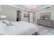 Luxurious bedroom with an ornate chandelier, and a view of the ensuite bath and walk-in closet at 8625 Brixford St, Orlando, FL 32836