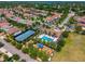 Aerial view of a community clubhouse featuring a pool, playground, tennis court, and lush landscaping at 8625 Brixford St, Orlando, FL 32836