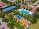 Aerial view of a community clubhouse featuring a pool, playground, tennis court, and lush landscaping at 8625 Brixford St, Orlando, FL 32836