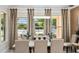 Elegant dining room features a modern chandelier, marble table and views of the backyard at 8625 Brixford St, Orlando, FL 32836