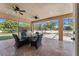 Covered patio featuring an outdoor kitchen, ceiling fans and view to the pool and screened-in enclosure at 8625 Brixford St, Orlando, FL 32836