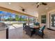 An outdoor kitchen and ceiling fans accent the covered travertine patio, offering views of the pool at 8625 Brixford St, Orlando, FL 32836