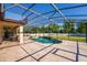 A covered patio featuring an outdoor kitchen, travertine tile and sparkling pool and jacuzzi at 8625 Brixford St, Orlando, FL 32836