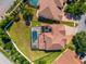 Aerial view of a backyard featuring a screened-in pool, spa, solar panels, and green lawn at 8625 Brixford St, Orlando, FL 32836