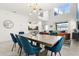 Open dining area with modern light fixture, large window, and view into the living room at 9179 Sommerset Hills Dr, Davenport, FL 33896