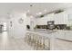 Contemporary kitchen with white cabinetry, gray countertops, island with seating, and modern fixtures at 9179 Sommerset Hills Dr, Davenport, FL 33896