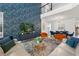 Stylish living room featuring a high ceiling, vibrant wallpaper, and chic decor at 9179 Sommerset Hills Dr, Davenport, FL 33896