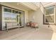 View of covered patio with a neutral couch and chairs with floral pillows at 9179 Sommerset Hills Dr, Davenport, FL 33896