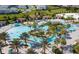 Community pool with lush landscaping, lounge chairs, water slide and plenty of space to relax at 9179 Sommerset Hills Dr, Davenport, FL 33896
